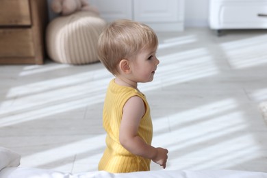Photo of Cute little baby in onesie at home