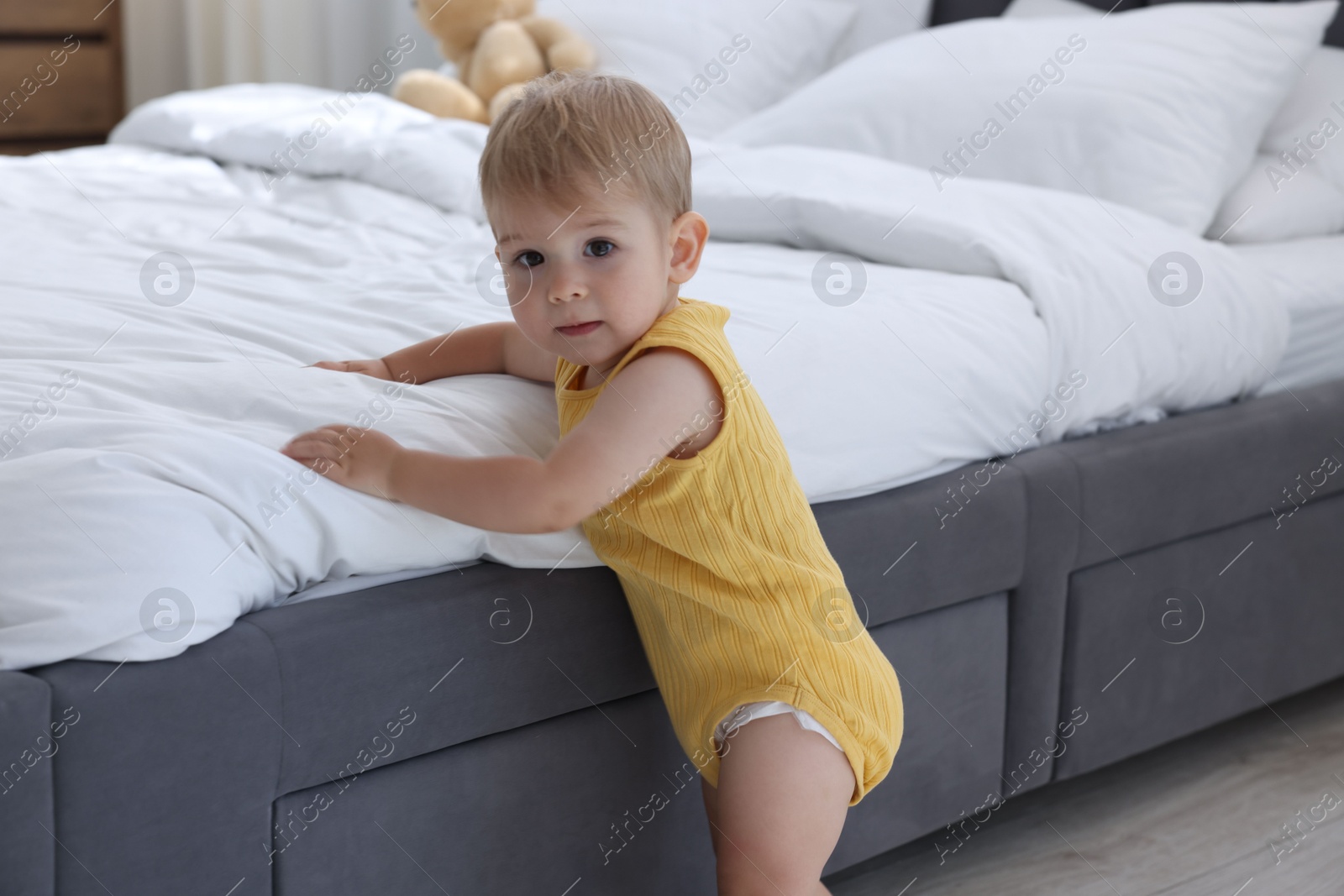 Cute little baby near bed at home Photo of Cute little baby near bed at home