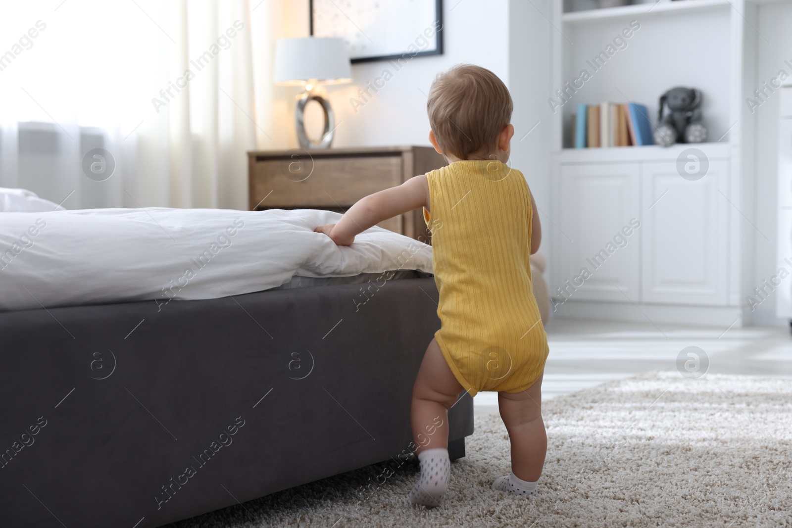 Cute little baby near bed at home Photo of Cute little baby near bed at home
