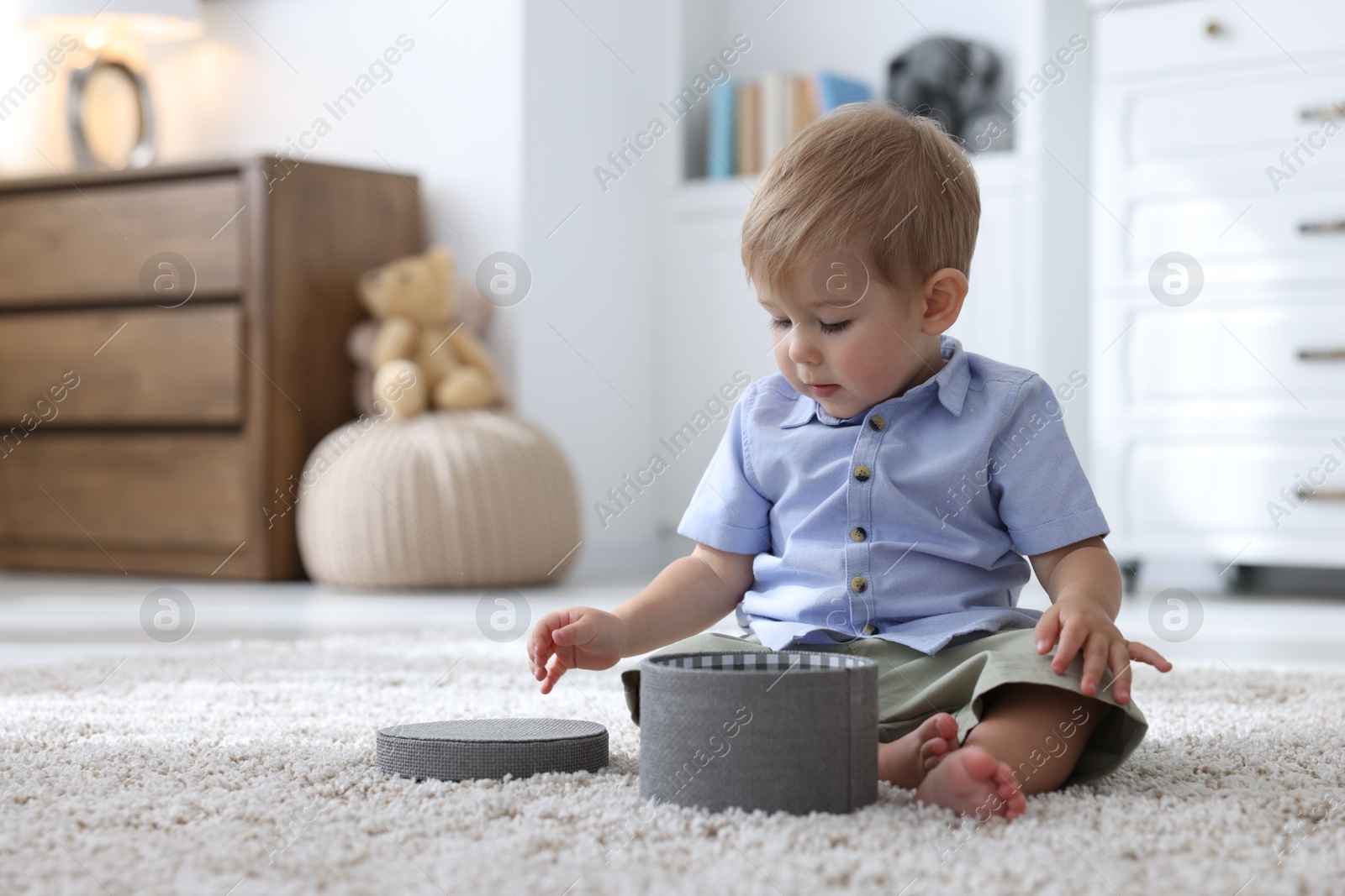 Photo of Cute little baby with decorative box on floor at home, space for text