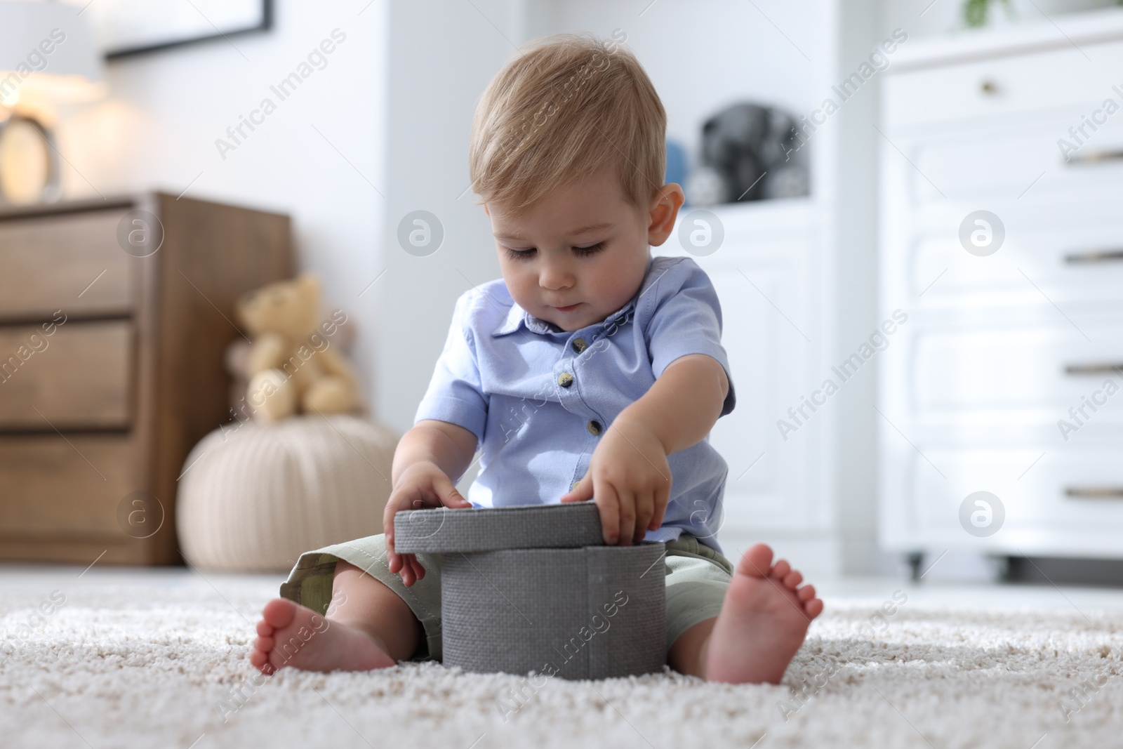 Cute little baby with decorative box on floor at home Photo of Cute little baby with decorative box on floor at home