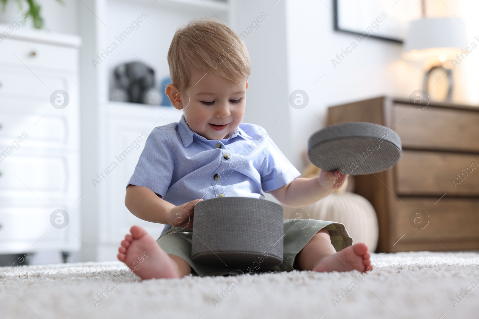 Cute little baby with decorative box on floor at home Photo of Cute little baby with decorative box on floor at home