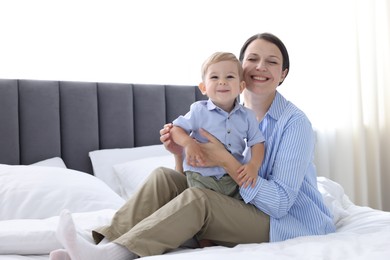 Photo of Mother with her cute little baby on bed at home