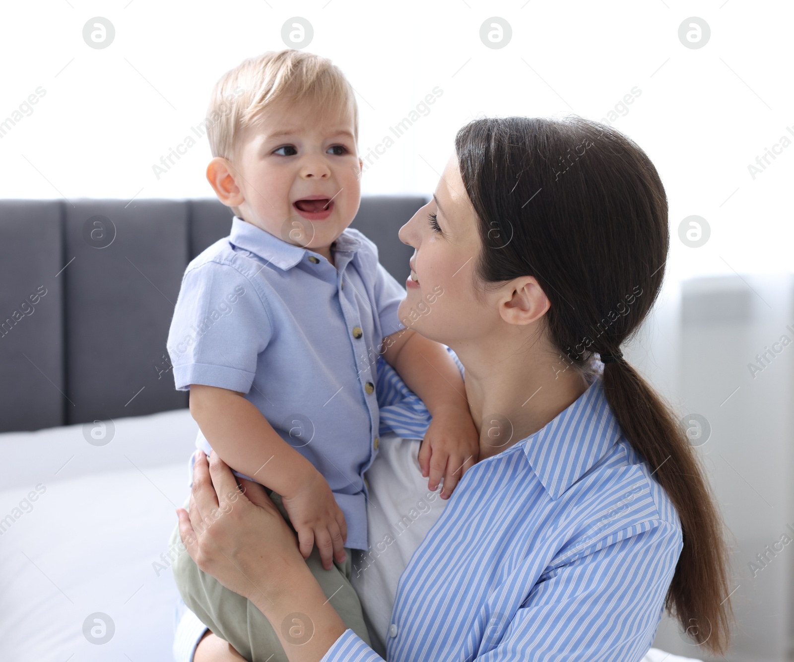 Mother with her cute little baby on bed at home Photo of Mother with her cute little baby on bed at home
