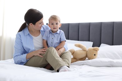 Photo of Mother with her cute little baby on bed at home