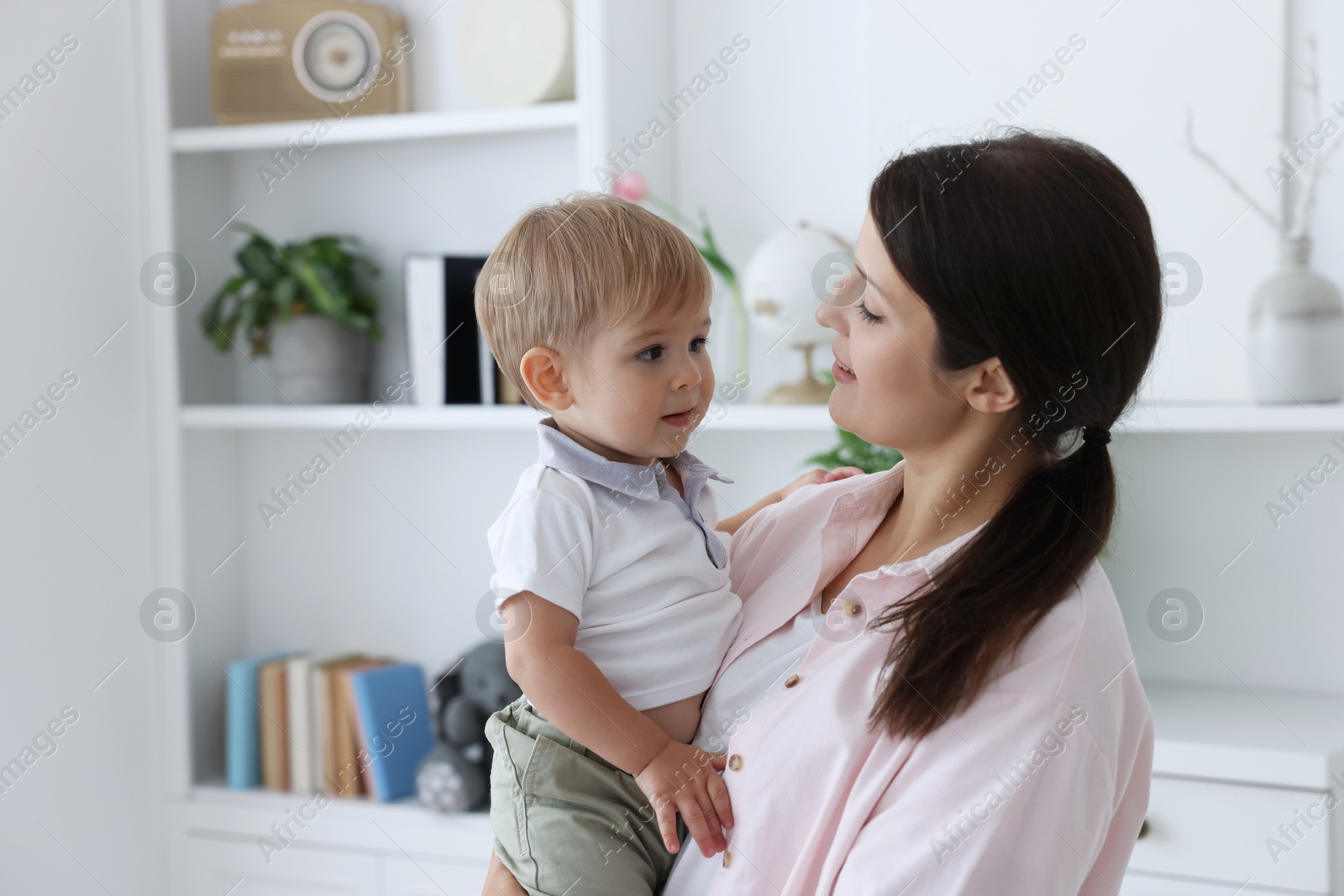 Photo of Mother with her cute little baby at home, space for text