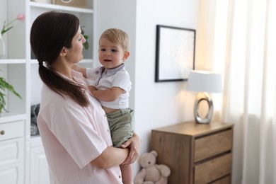 Photo of Mother with her cute little baby at home, space for text