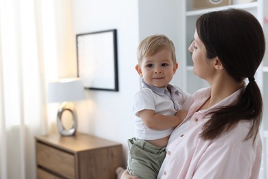 Photo of Mother with her cute little baby at home, space for text