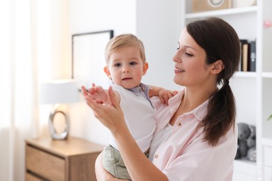 Photo of Mother with her cute little baby at home, space for text