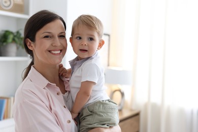 Photo of Mother with her cute little baby at home, space for text