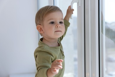 Photo of Cute little baby near window at home