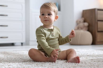 Photo of Cute little baby on floor at home