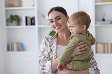 Photo of Mother with her cute little baby at home, space for text