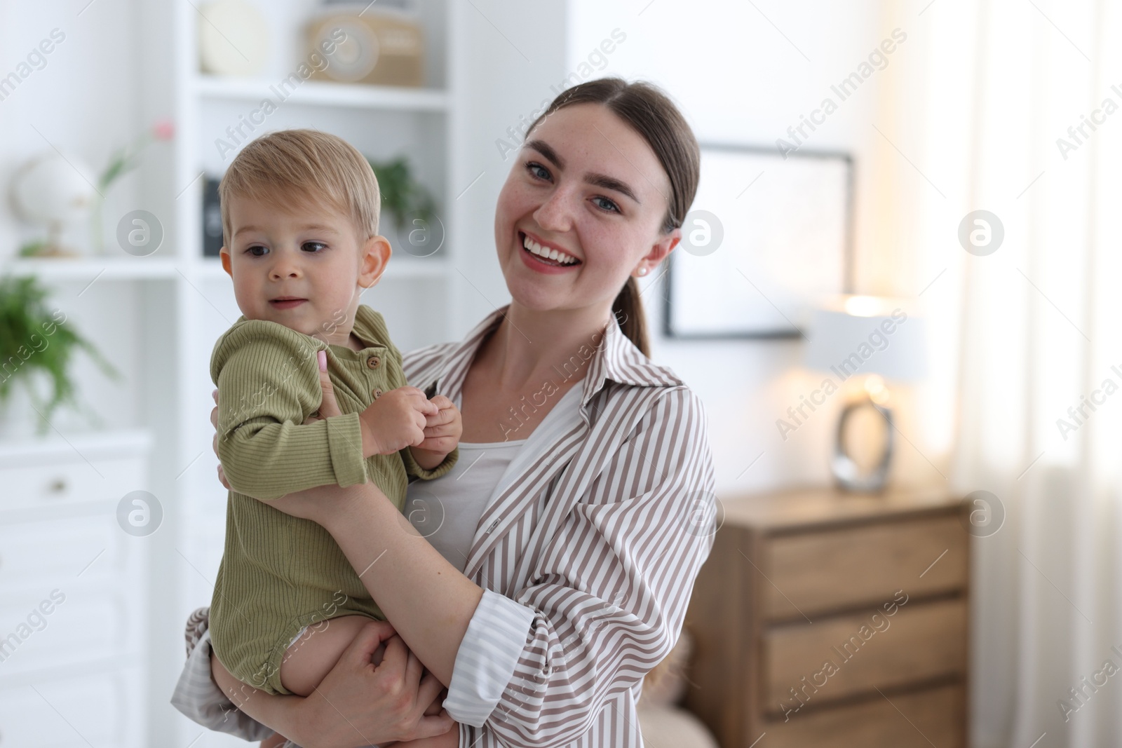Photo of Mother with her cute little baby at home, space for text
