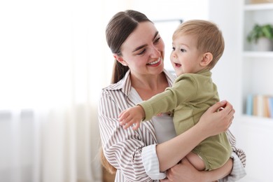 Photo of Mother with her cute little baby at home, space for text
