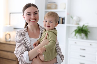 Photo of Mother with her cute little baby at home, space for text