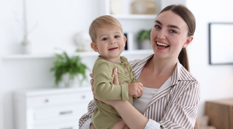 Photo of Mother with her cute little baby at home, space for text
