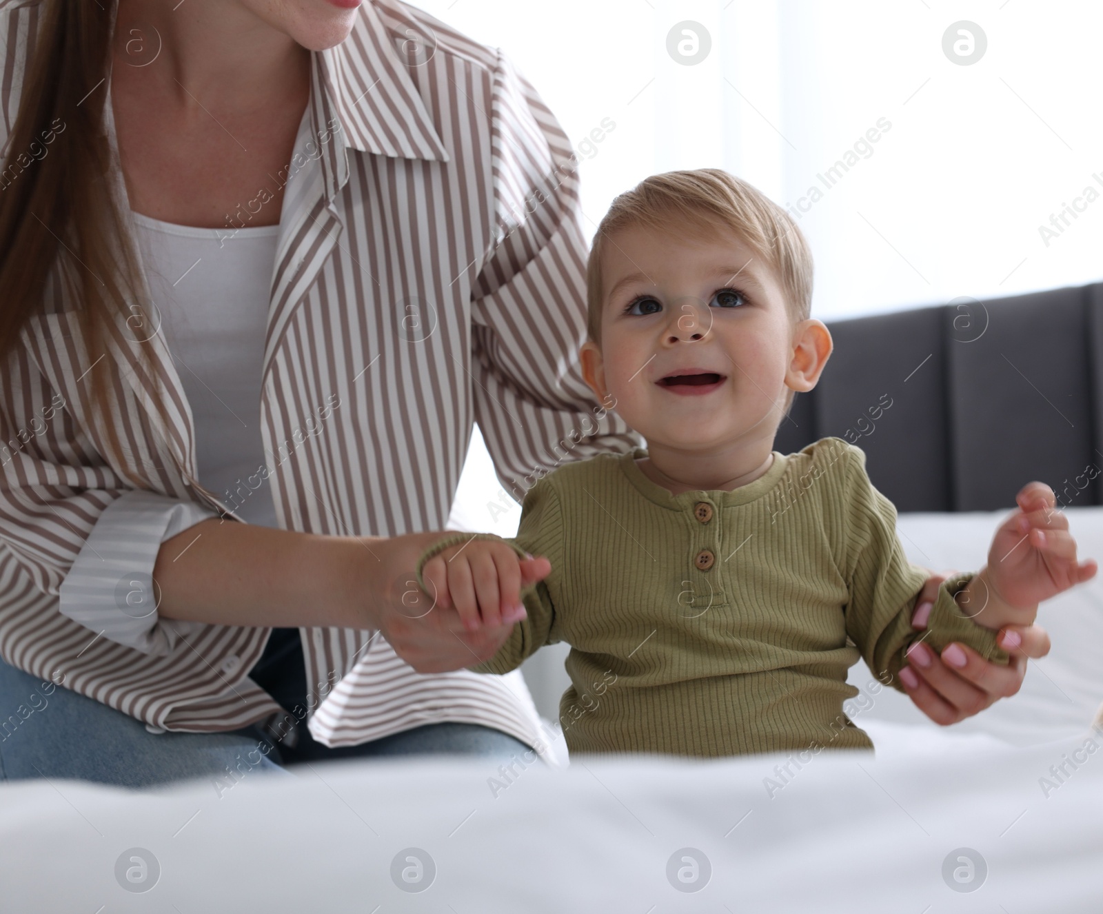 Mother with her cute little baby on bed at home, closeup Photo of Mother with her cute little baby on bed at home, closeup