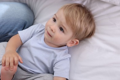 Photo of Cute little baby on bed at home, above view