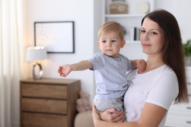 Photo of Mother with her cute little baby at home, space for text