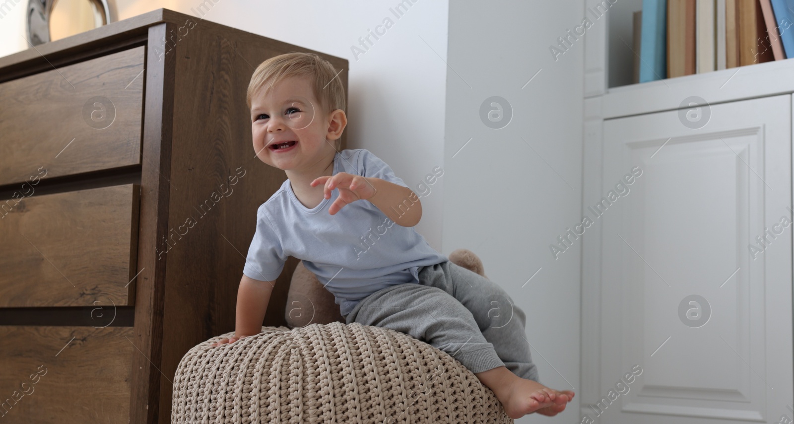 Cute little baby on pouf at home Photo of Cute little baby on pouf at home