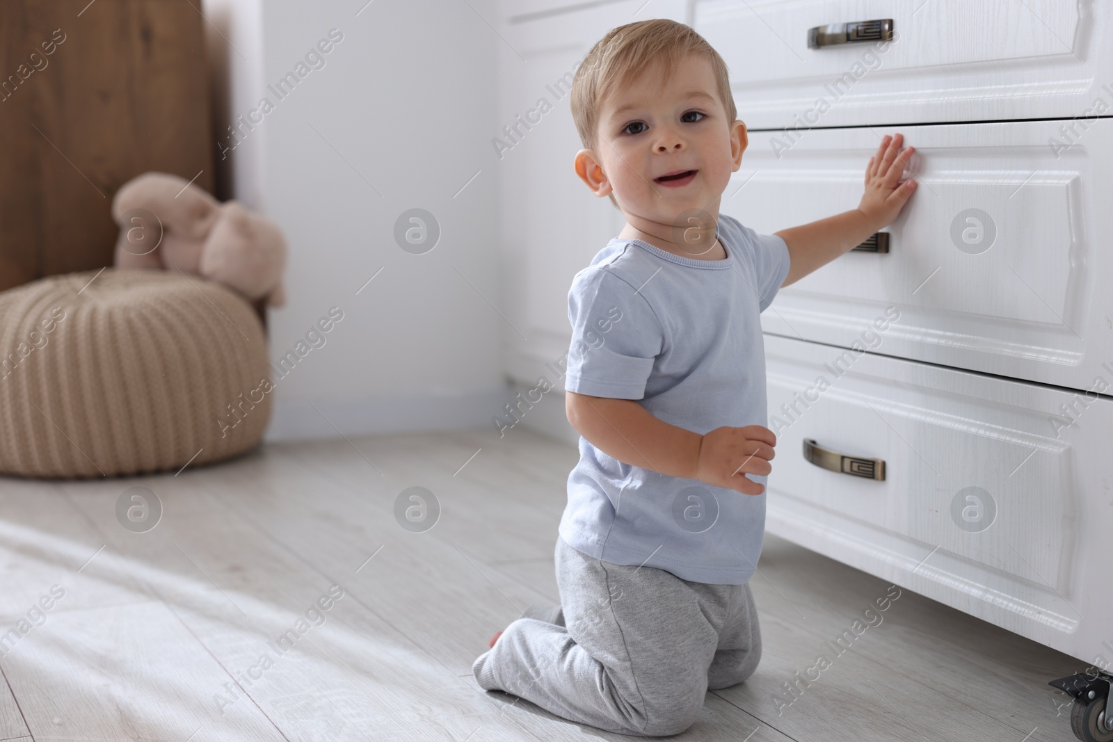 Photo of Cute little baby near dresser at home, space for text