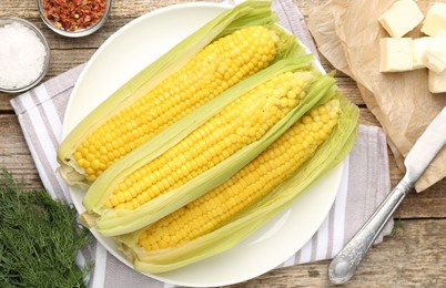 Photo of Tasty boiled corncobs, dill and spices on wooden table, flat lay