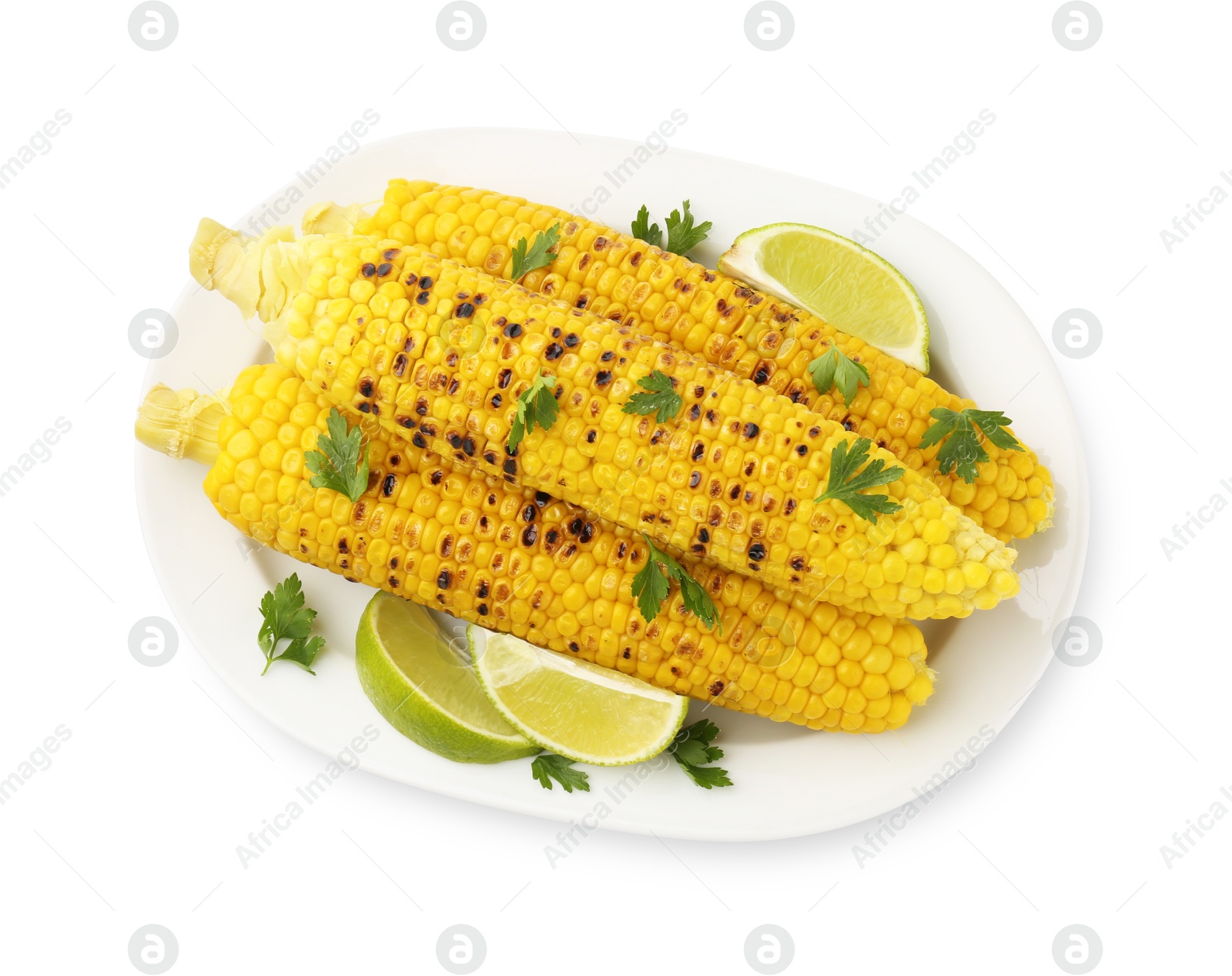 Photo of Tasty grilled corncobs with parsley and lime slices isolated on white, top view