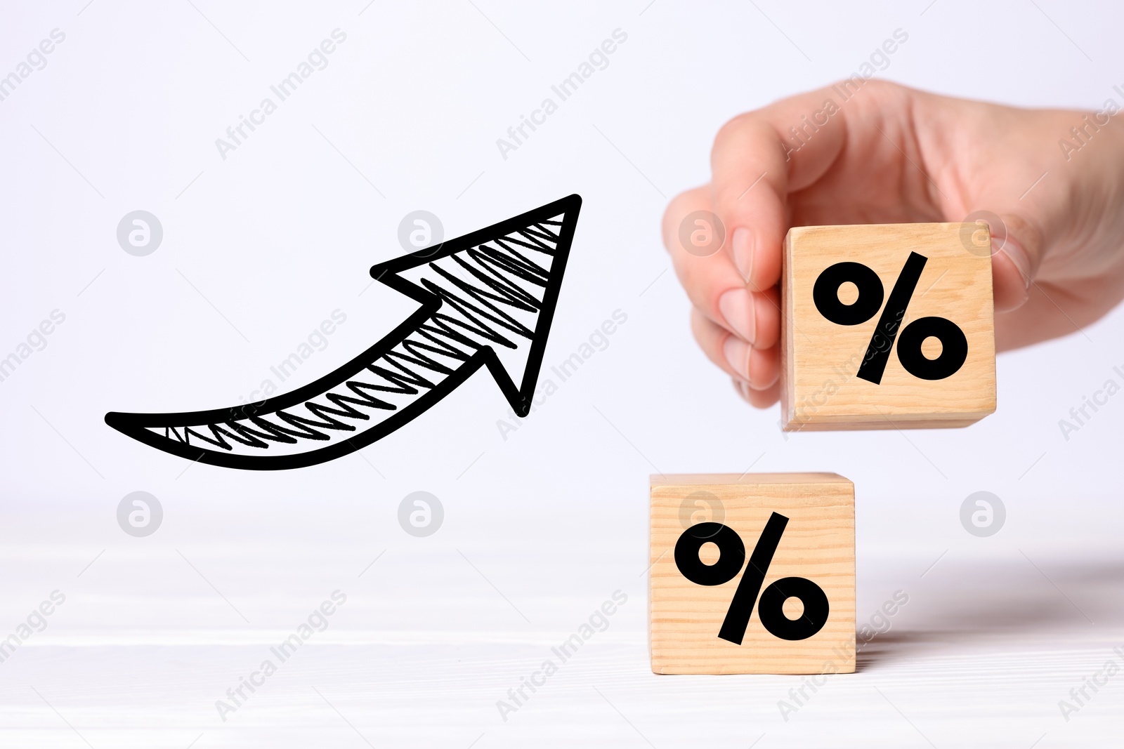 Image of Man holding wooden cube with percent sign against white background, closeup