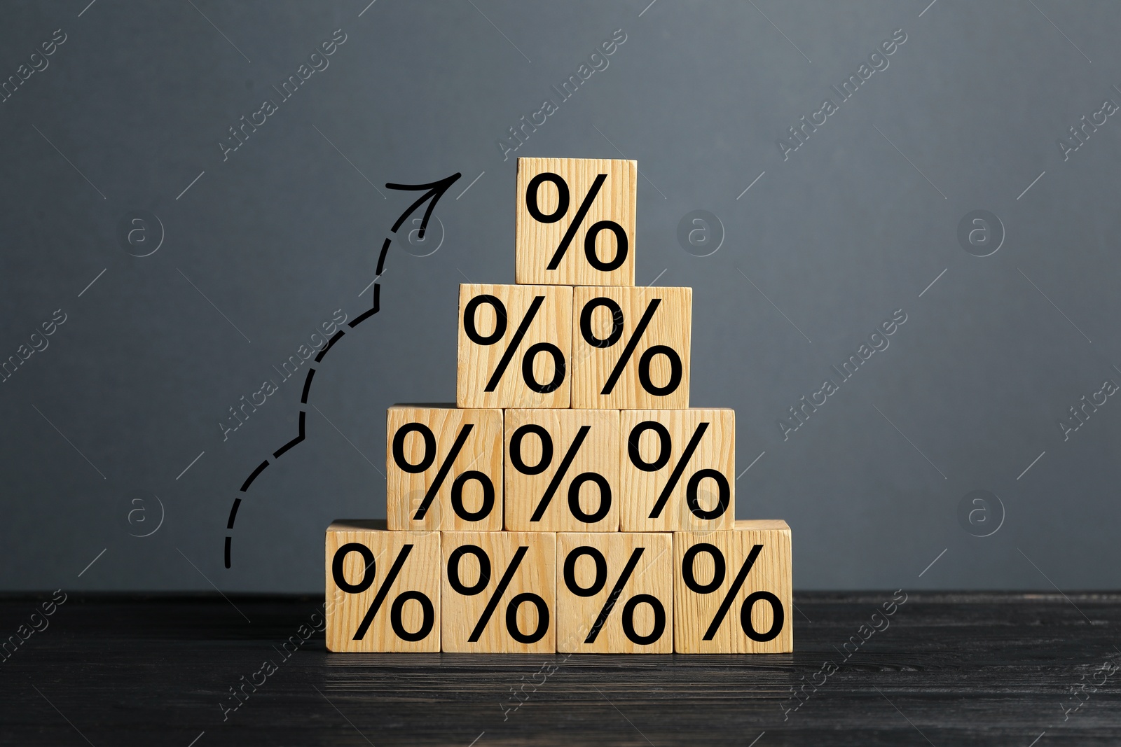 Image of Percent signs on wooden cubes and arrow against grey background