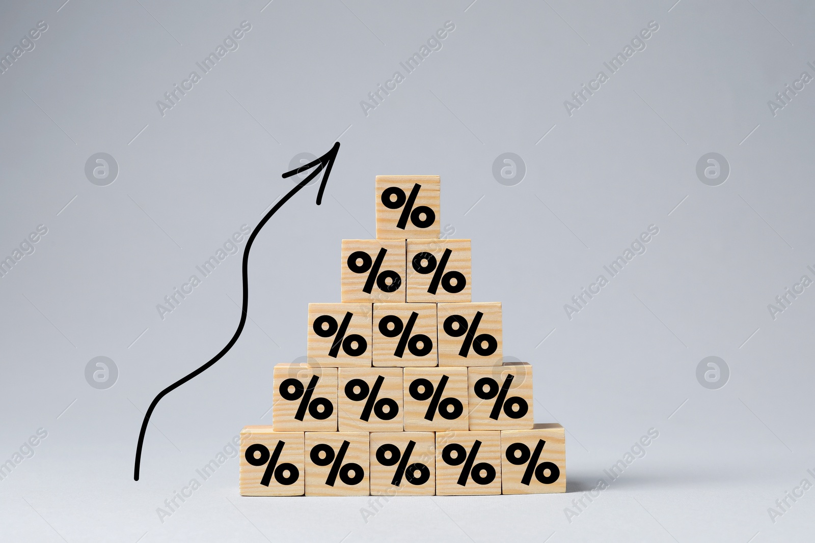 Image of Percent signs on wooden cubes and arrow against grey background