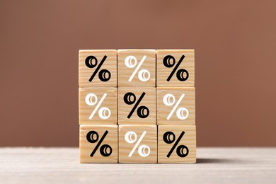 Image of Percent signs on wooden cubes against brown background