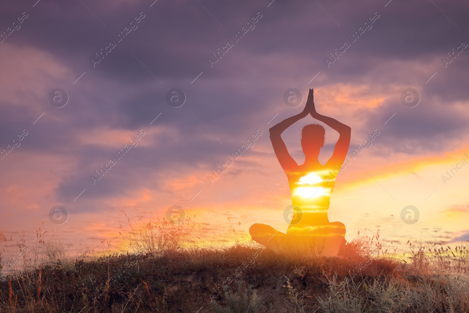 Practicing yoga in nature. Woman meditating in lotus position on hill. Double exposure with sunset sky Image of Practicing yoga in nature. Woman meditating in lotus position on hill. Double exposure with sunset sky