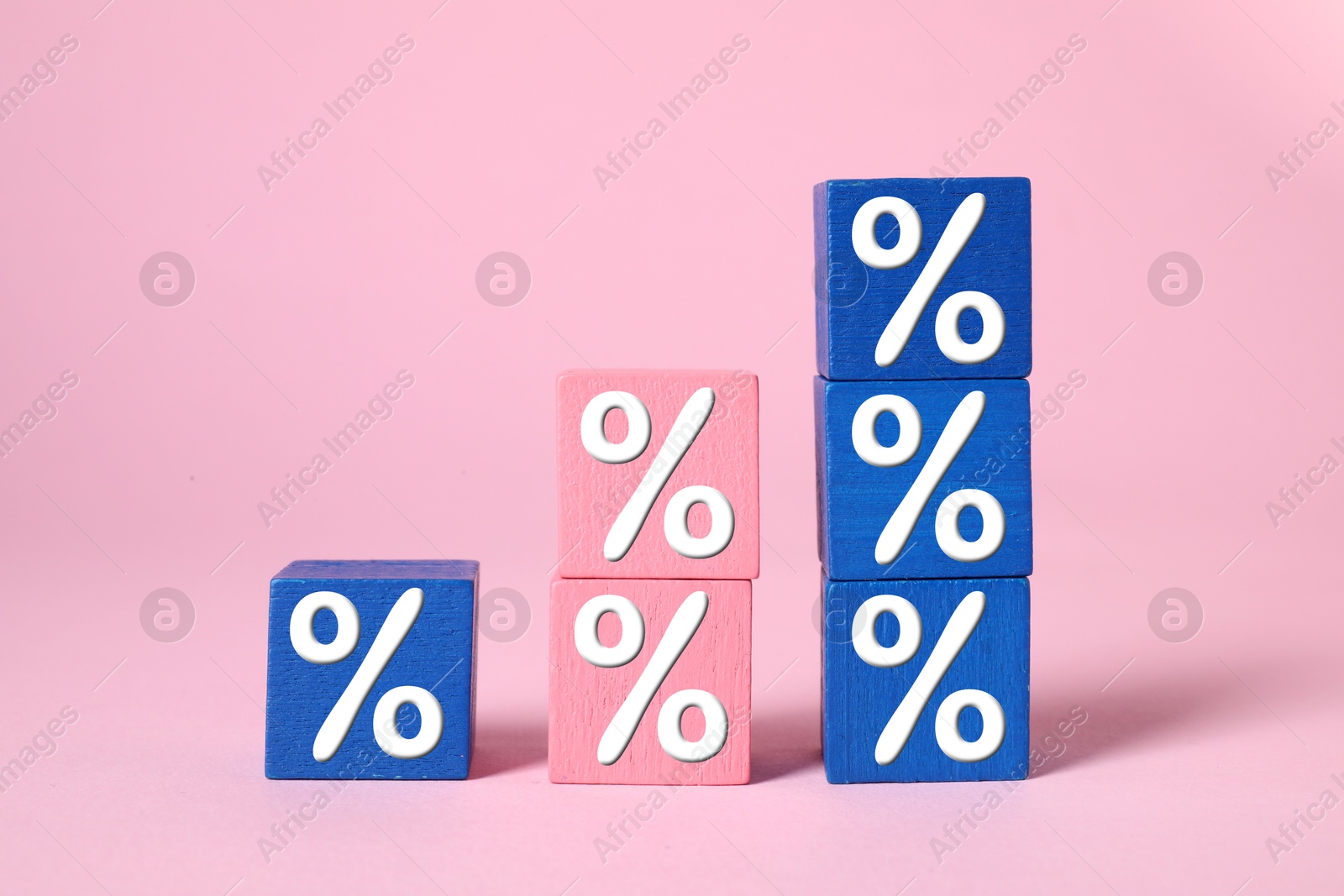 Image of Percent signs on colorful cubes against pink background