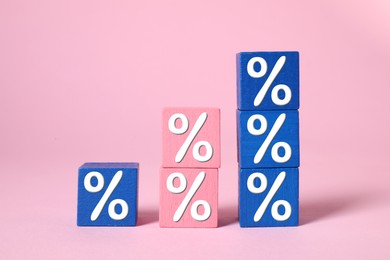 Image of Percent signs on colorful cubes against pink background