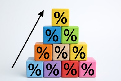 Image of Percent signs on colorful cubes and arrow against white background