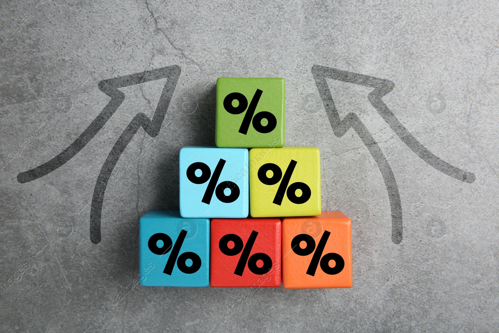 Image of Colorful cubes with percent signs and arrows on grey textured background, top view