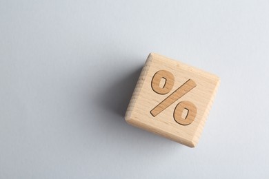 Image of Wooden cube with percent sign on light grey background, top view. Space for text