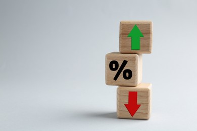 Image of Cubes with percent sign, up and down arrows against grey background. Space for text