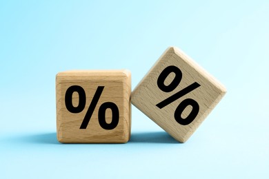 Image of Percent signs on wooden cubes against light blue background