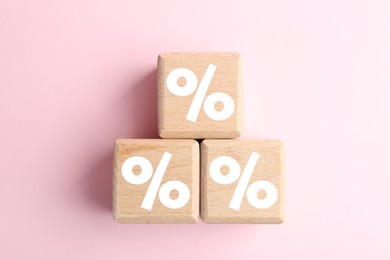 Image of Wooden cubes with percent signs on pink background, top view