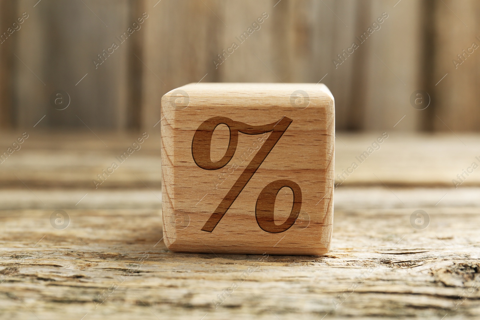Cube with percent sign on wooden table, closeup Image of Cube with percent sign on wooden table, closeup