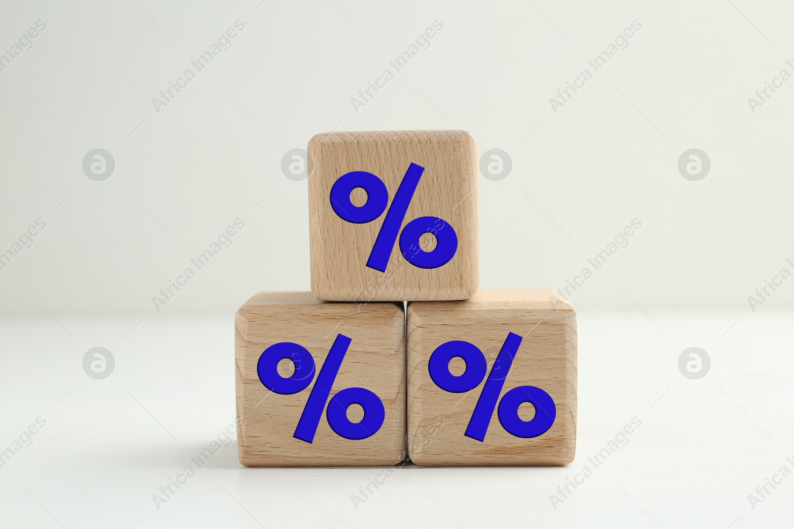 Percent signs on wooden cubes against light background Image of Percent signs on wooden cubes against light background