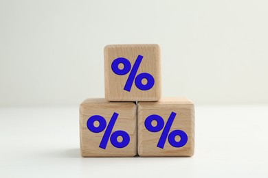 Image of Percent signs on wooden cubes against light background
