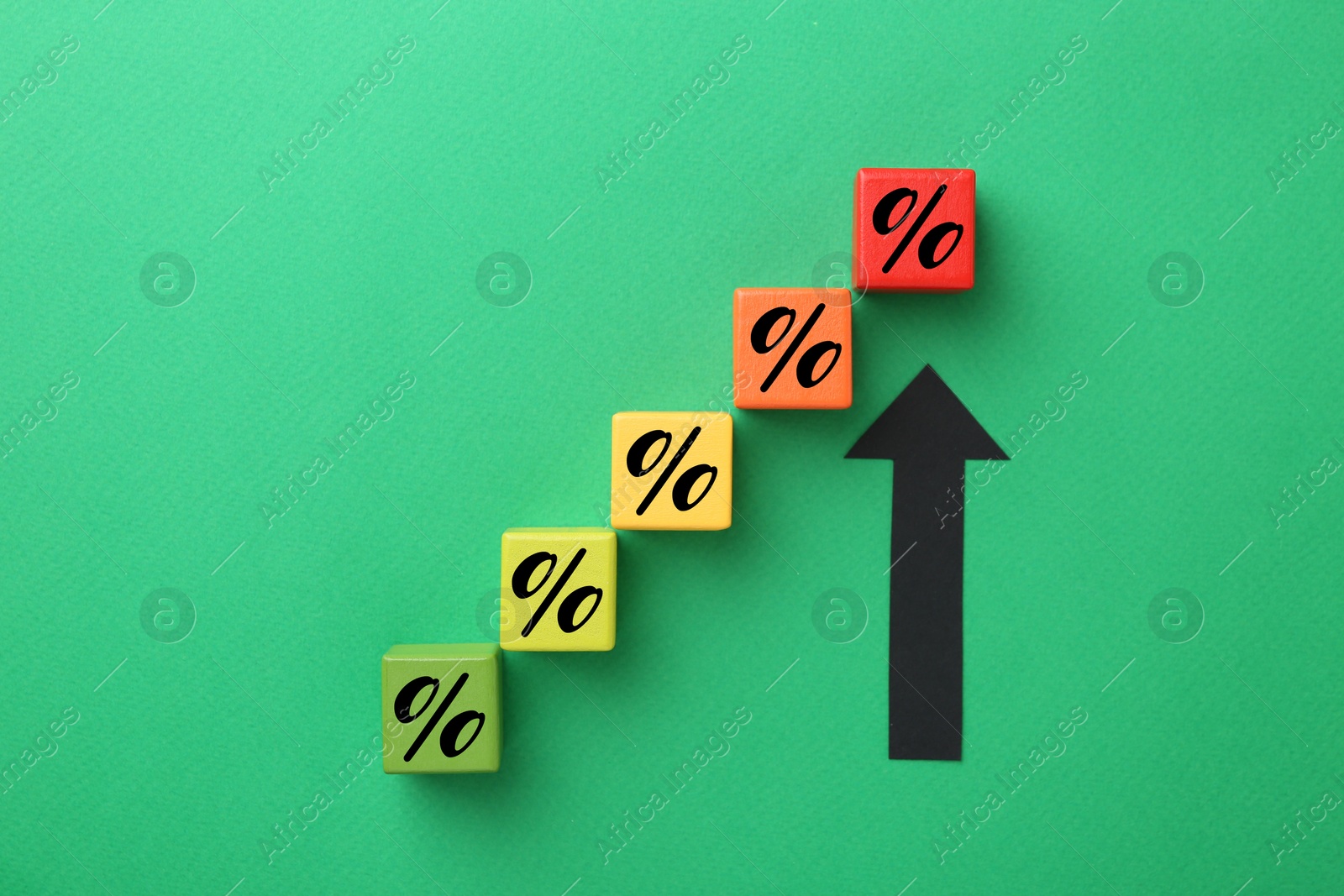 Colorful cubes with percent signs and arrow on green background, top view Image of Colorful cubes with percent signs and arrow on green background, top view