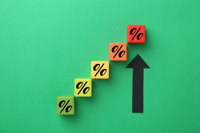 Image of Colorful cubes with percent signs and arrow on green background, top view