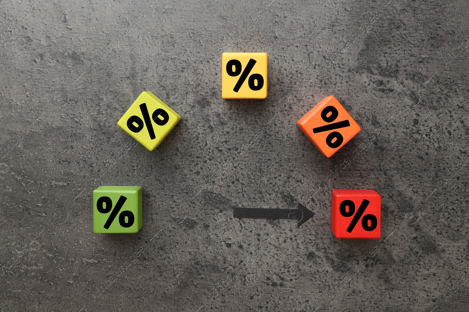 Image of Colorful cubes with percent signs and arrow on grey textured table, top view