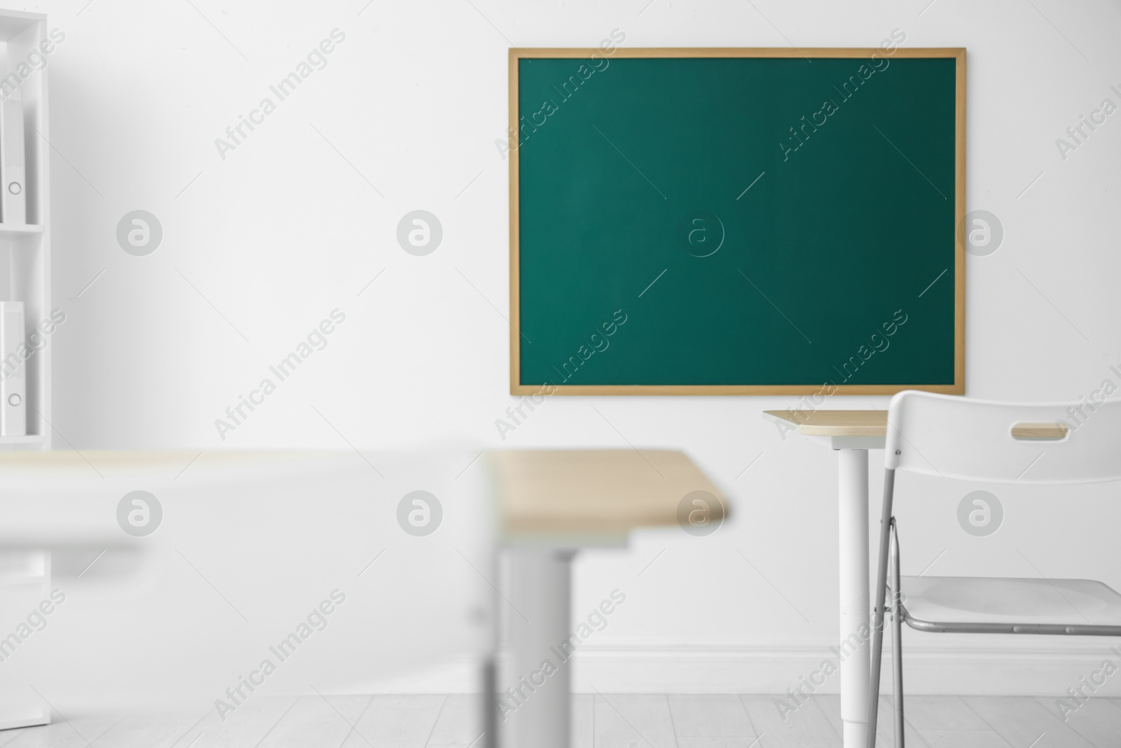 Blank green chalkboard, desks and chairs in classroom Photo of Blank green chalkboard, desks and chairs in classroom