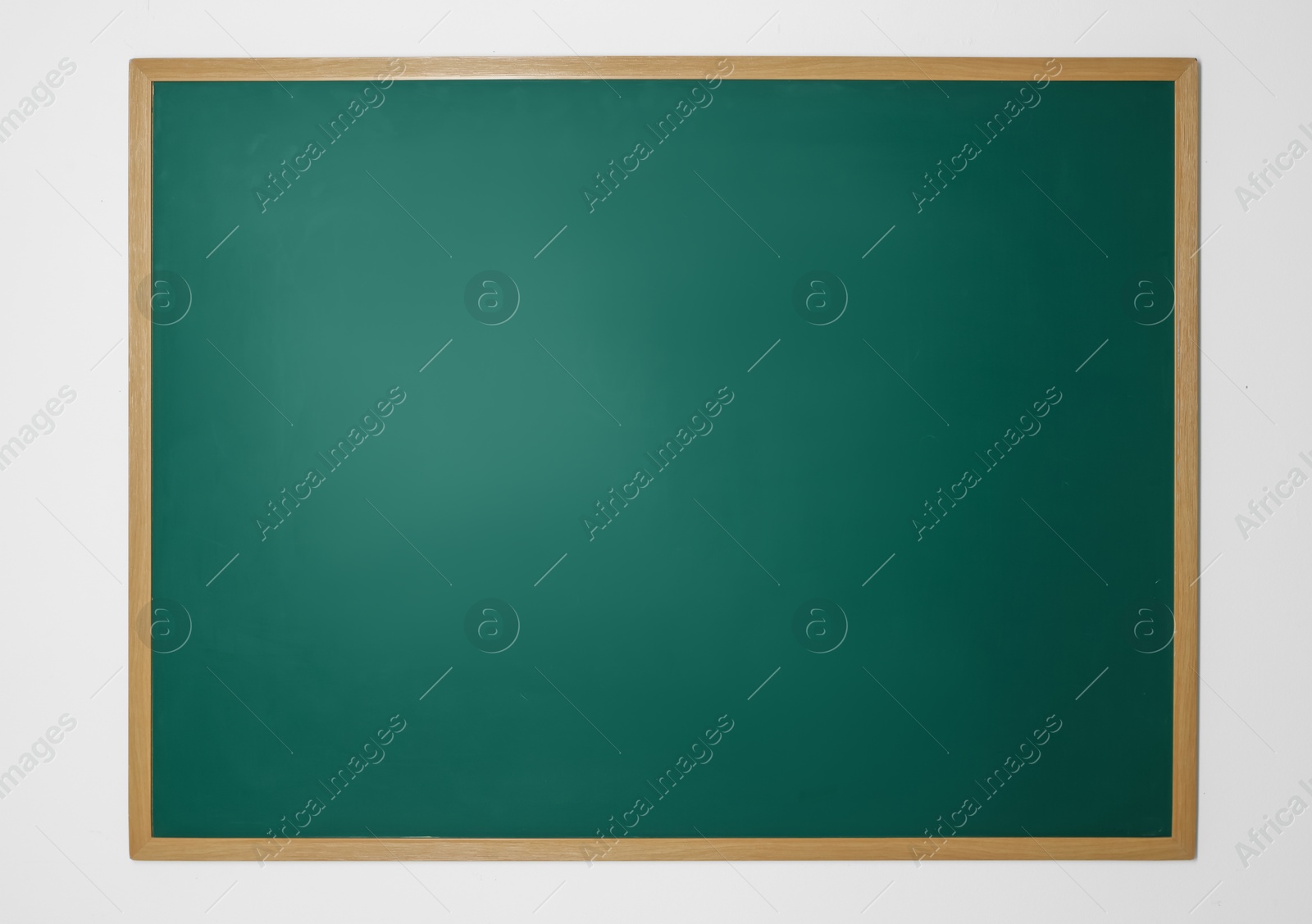 Photo of Blank green chalkboard on white wall indoors