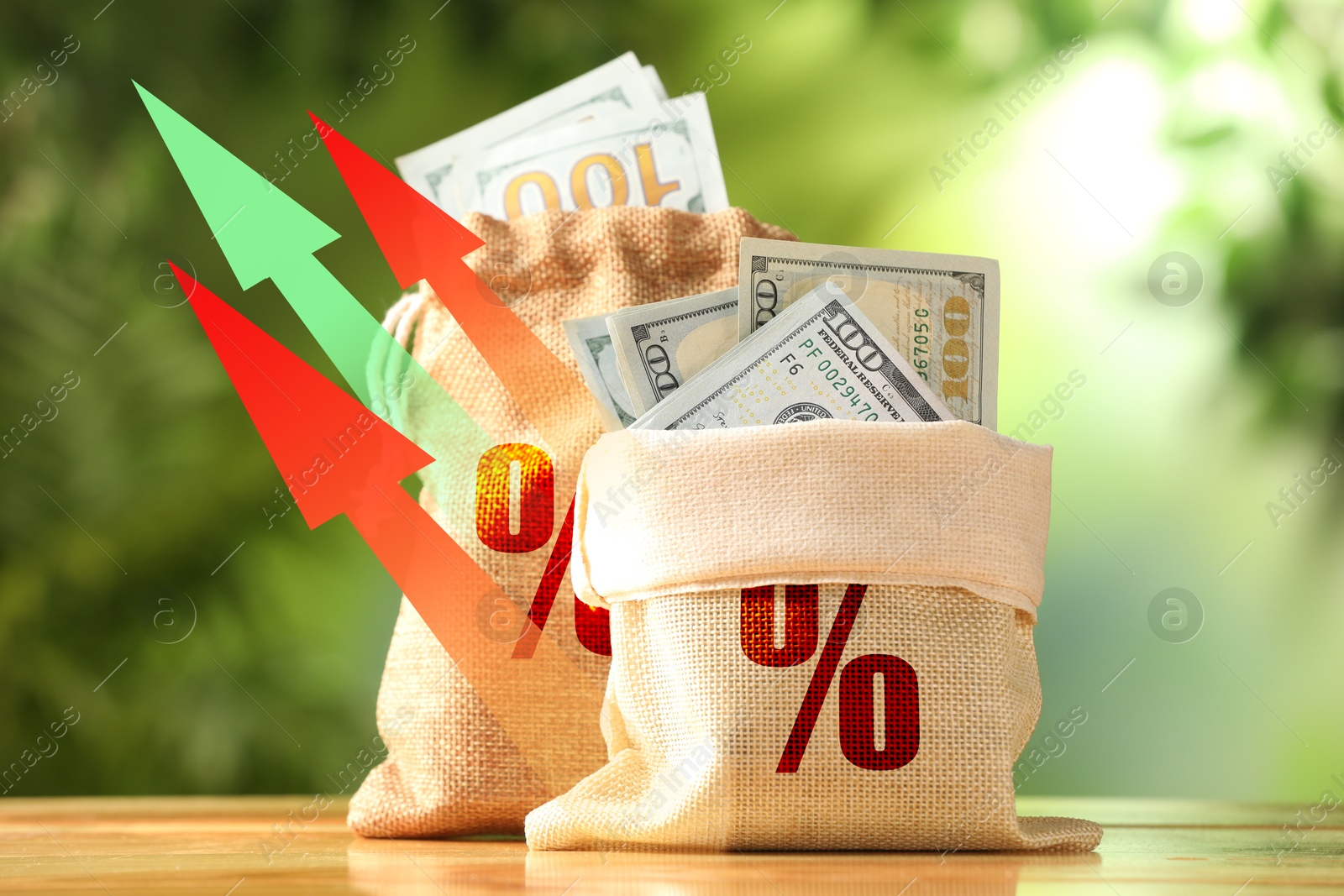 Burlap bags with percent signs full of money and arrows against blurred green background Image of Burlap bags with percent signs full of money and arrows against blurred green background